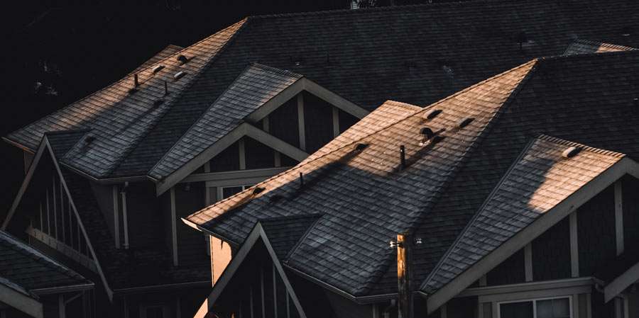 Gabled roofs of houses at dusk.