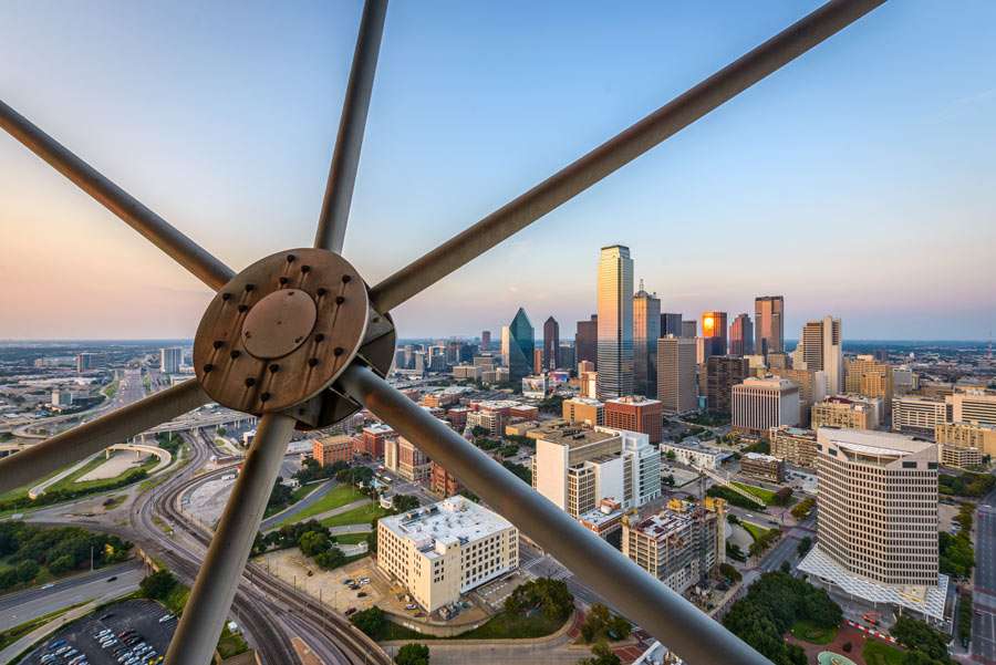 City skyline at dusk through metal framework.